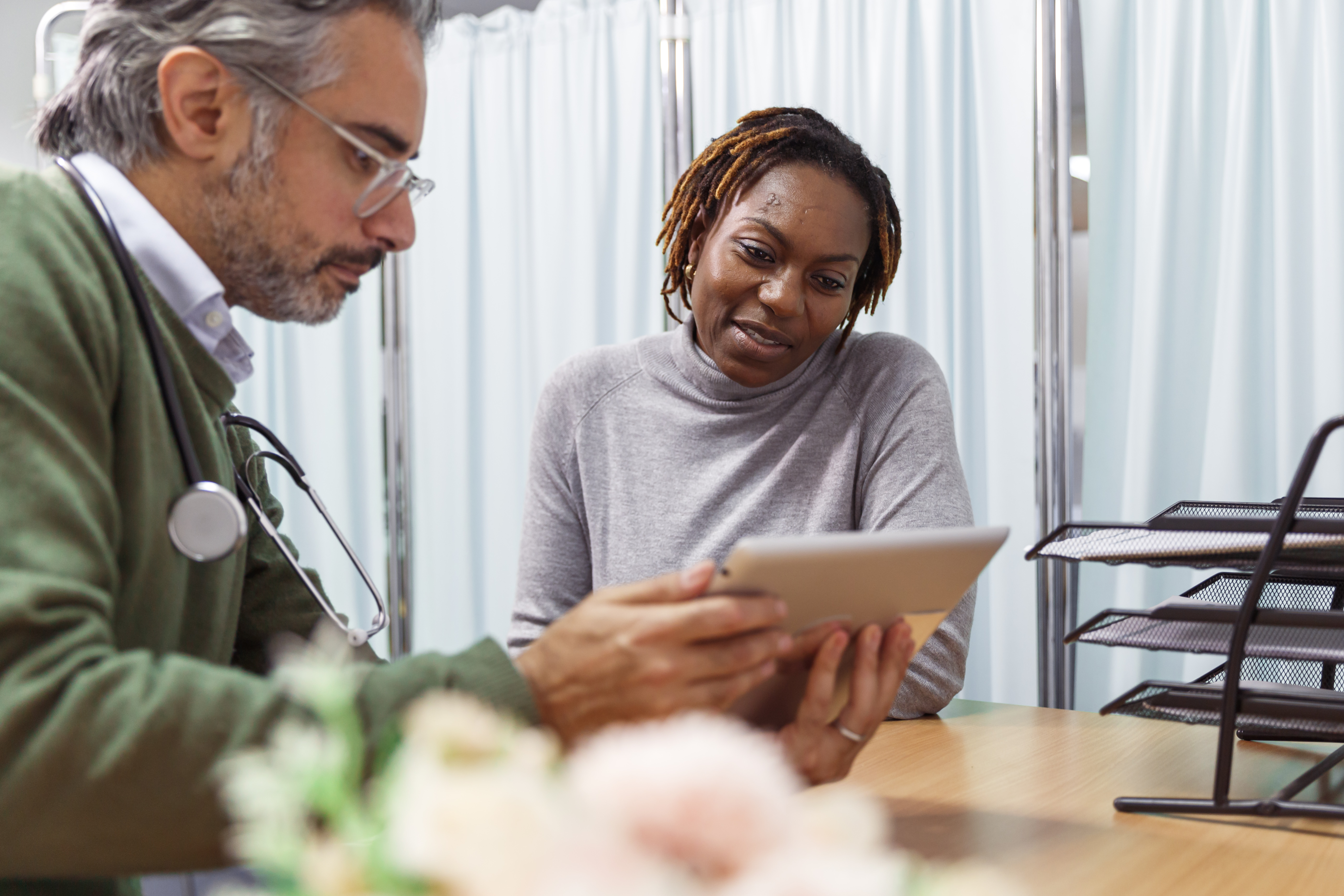 Doctor holding up ipad to show patient some information