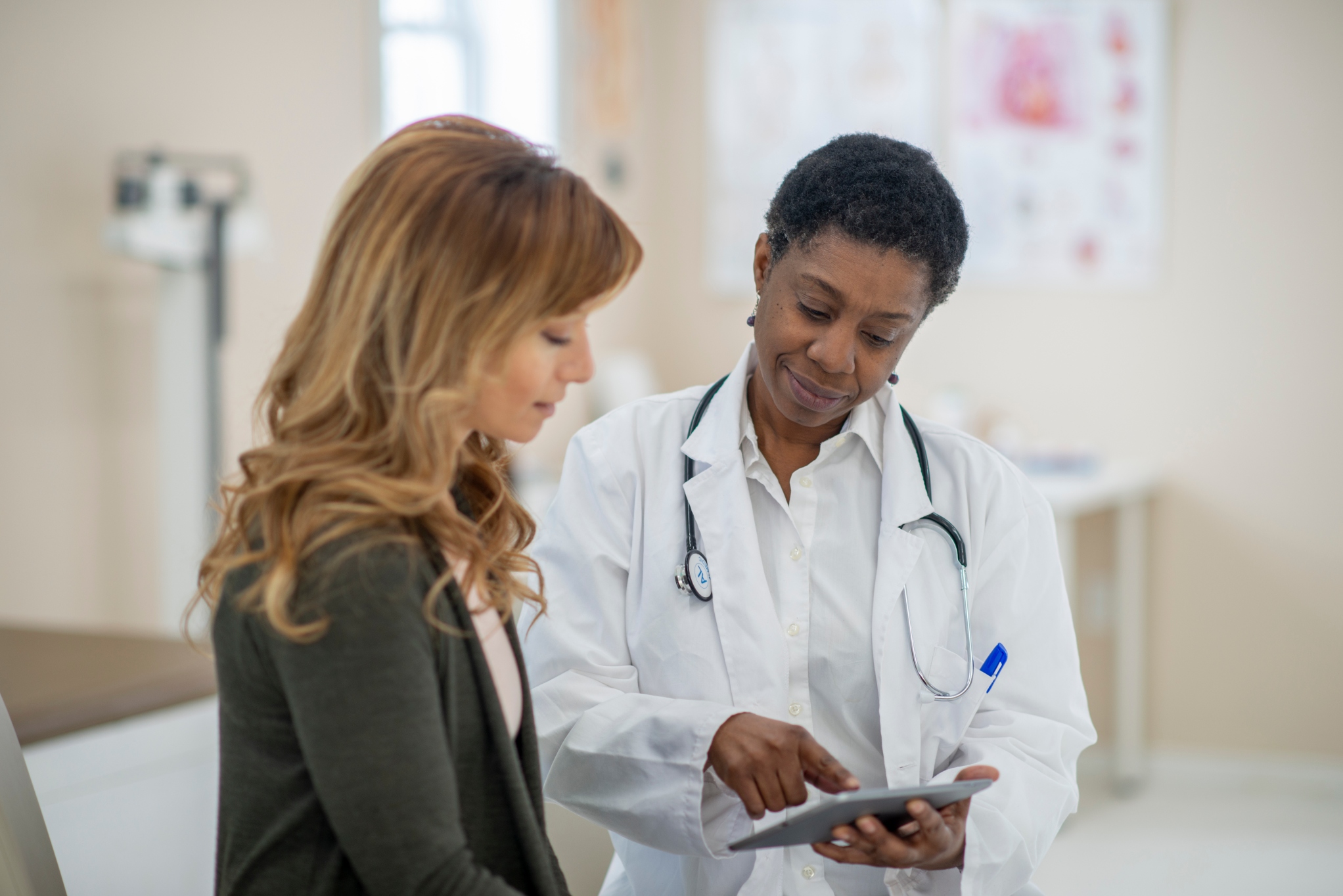 Female doctor showing woman information on a screen