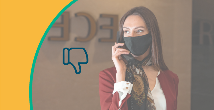 Receptionist with mask on phone, thumbs down
