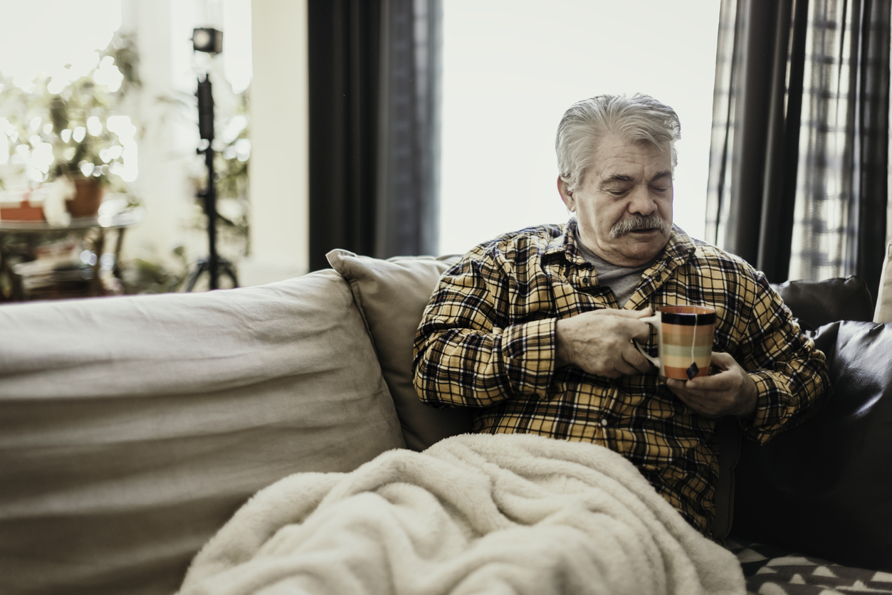 Man holding hot drink and trying to stay warm