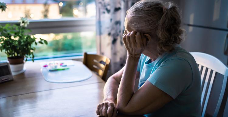Woman sat at table looking out of window