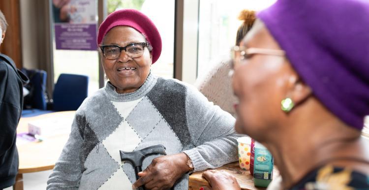 Two ladies sat in a community space talking