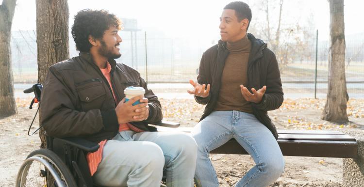 Two males sat in park talking