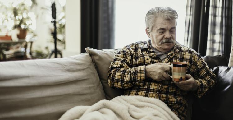 Man warming up hands with coffee