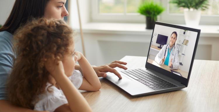 lady and little girl looking at a laptop