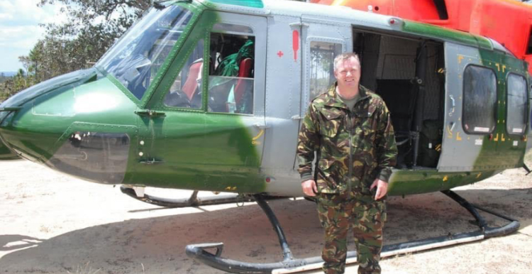 male veteran stood in front of army helicopter