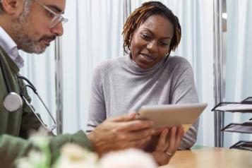 male doctor showing female patient information on device