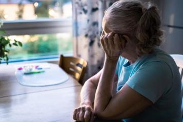 Woman sat at table looking out of window
