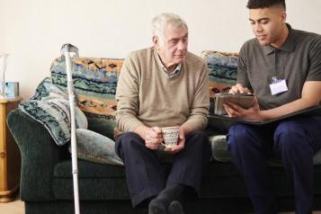 two men looking at ipad