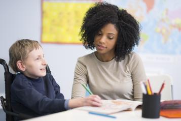 Child with disability being taught how to write