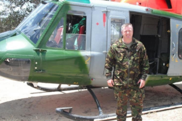 male veteran stood in front of army helicopter